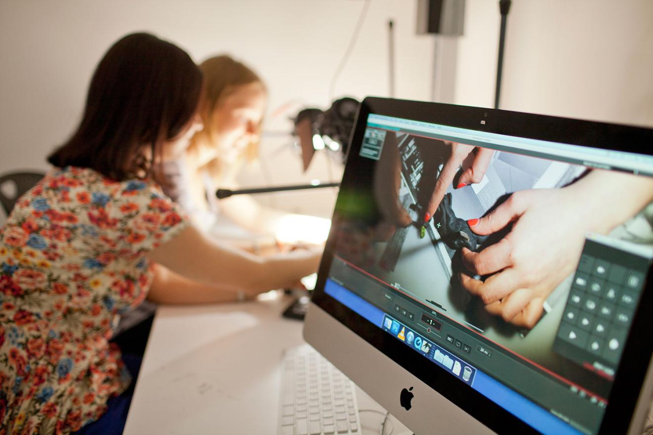 Apple imac with on a table with 2 women in background