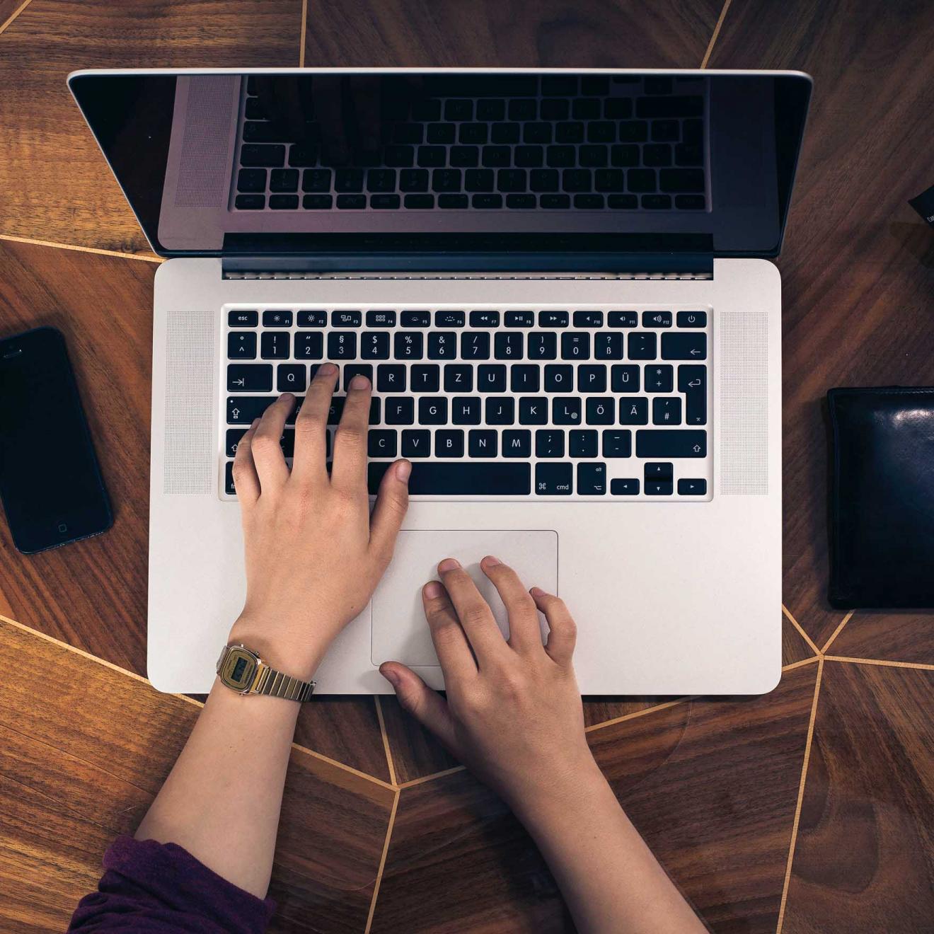 Photo of a woman's hands using a laptop keyboard