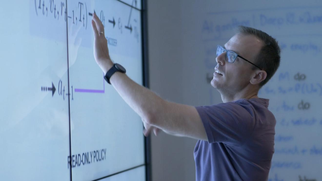 QSI Dr Christopher Ferrie presenting in front of a large monitor