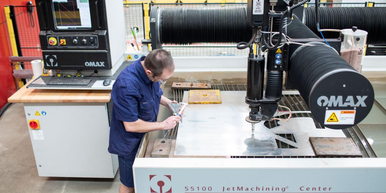 A man double checks the calibration on the JetMachining Center