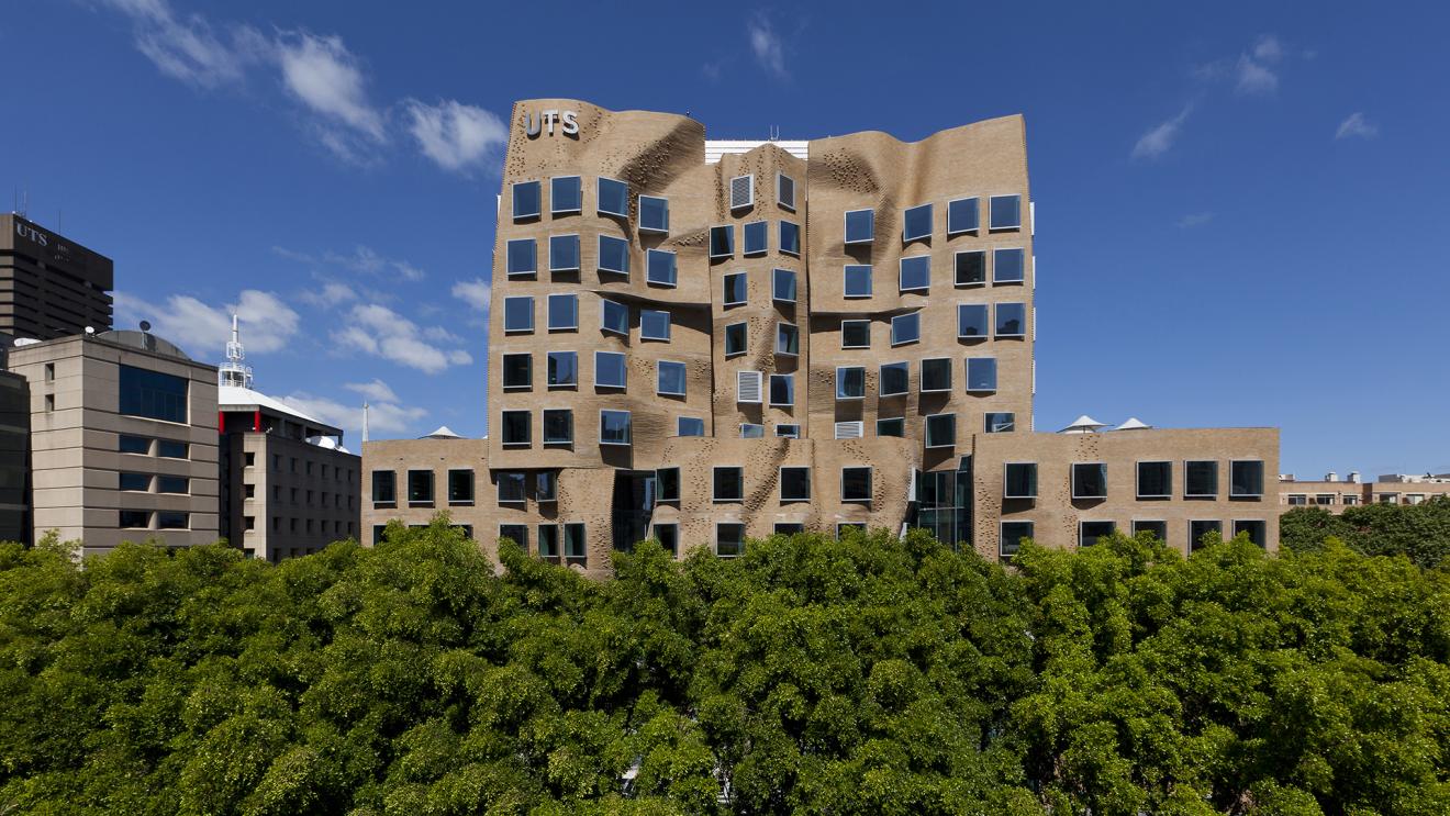 The crumpled brown brick form of the Dr Chau Chak Wing building sits over a green tree line