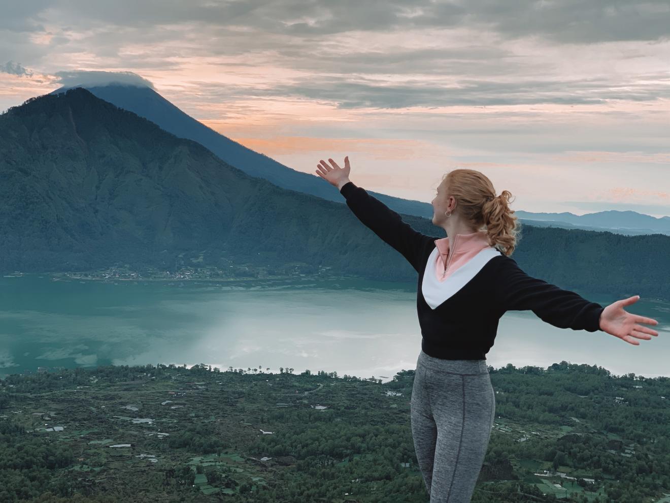 Woman at lake with open arms