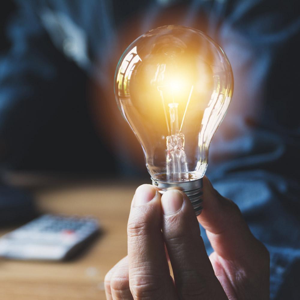 Glowing lightbulb in man's hand