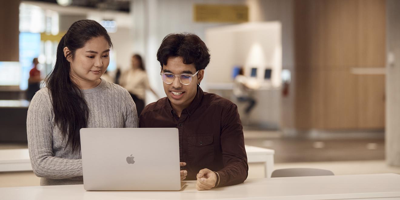 Two students sharing a laptop and collaborating inside UTS modernised campus