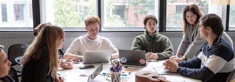 Industry partner helping group of BCII students at square table
