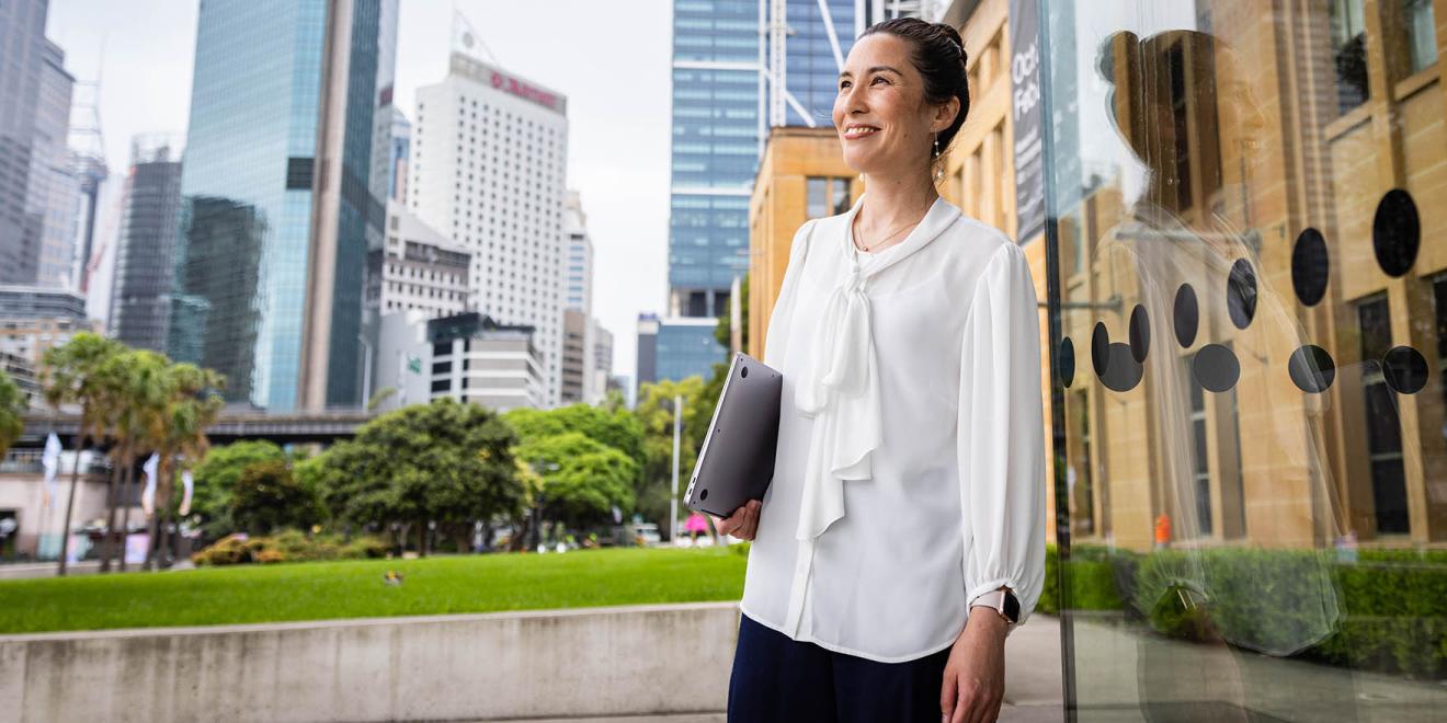 Woman walking around university campus with buildings in background