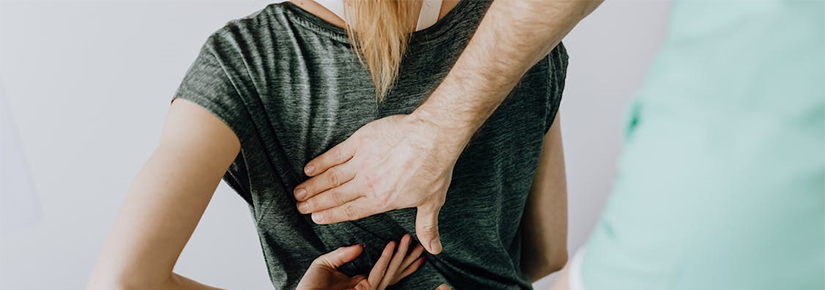Clinician examining patient for back pain