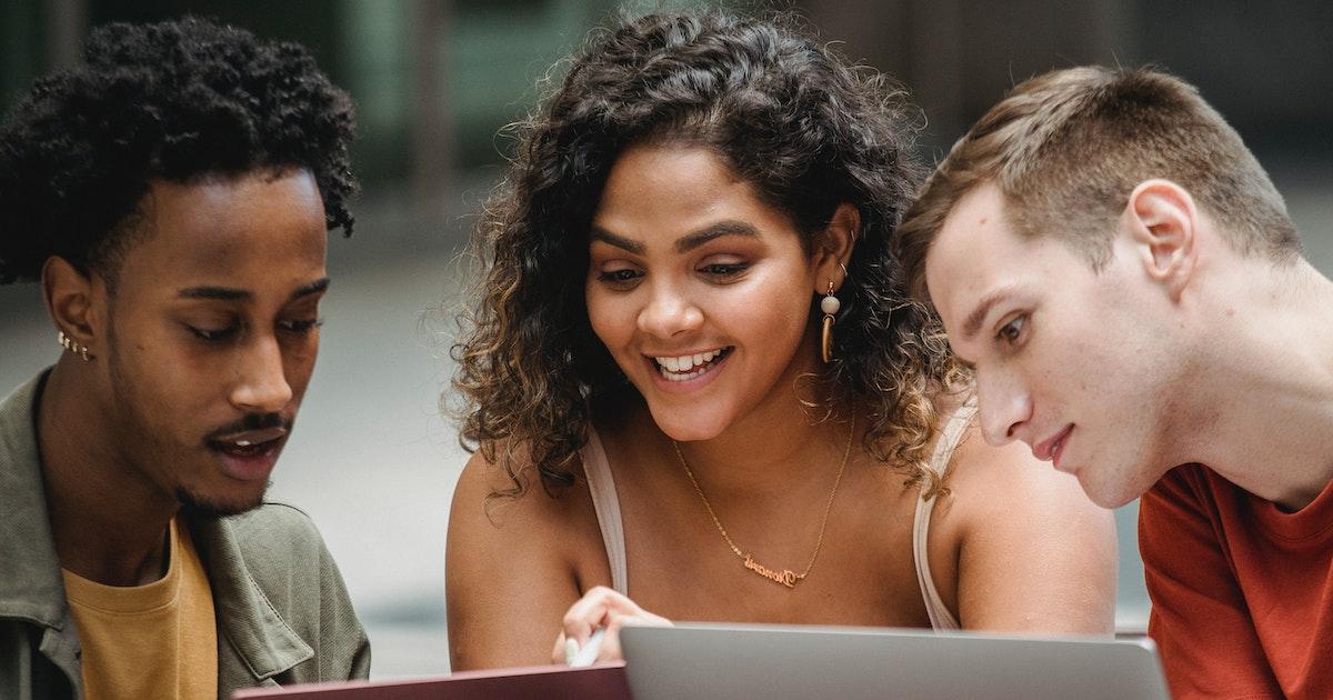 three students looking at laptop