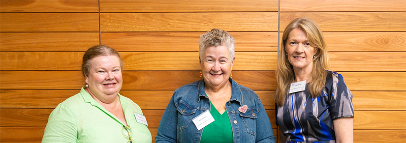 Joanne Cooper, Fiona Lysaught and Linda Brown staning in front of wood-panelled wall. 