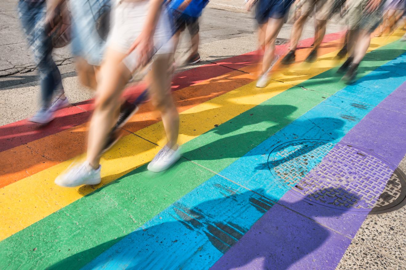 People walking over a rainbow crossing