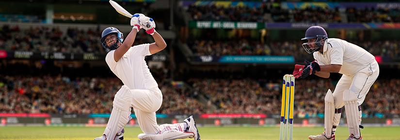 Cricketer batsman hitting a shot during a match on the cricket pitch during a match By IndiaPix