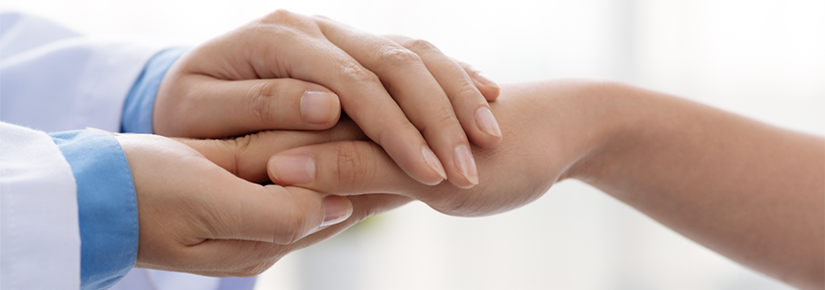 A doctor holding hands with a patient