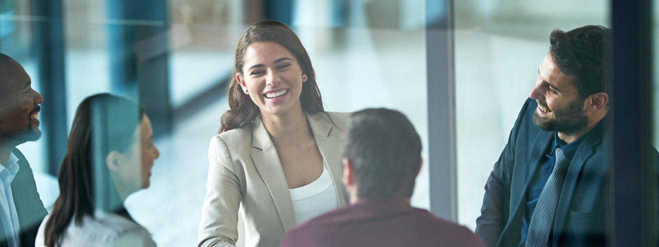 Closed meeting discussion behind glass with friendly faces