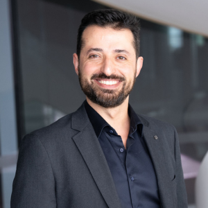 A picture of Hadi Afshar, male, black hair and beard, wearing a black suit