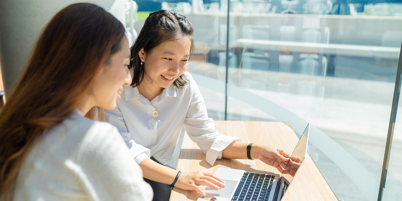 Two students using a laptop