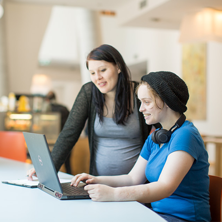 Two UTS student looking at the UTS Accessibility website on a laptop