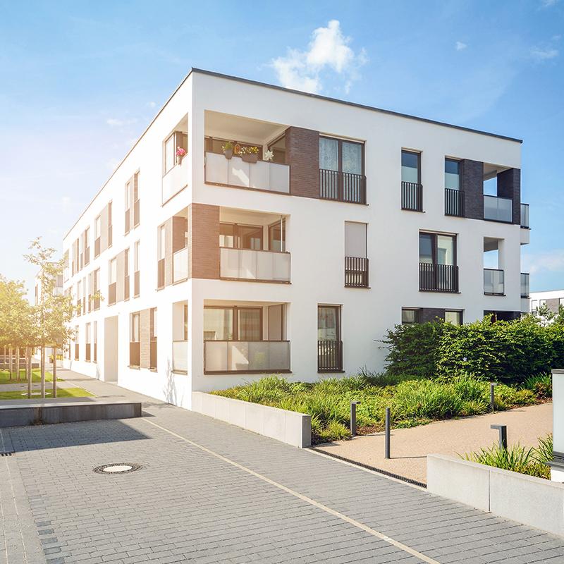 A modern block of flats with a blue sunny sky in the background