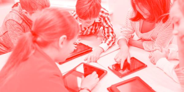 Young students typing on iPads.