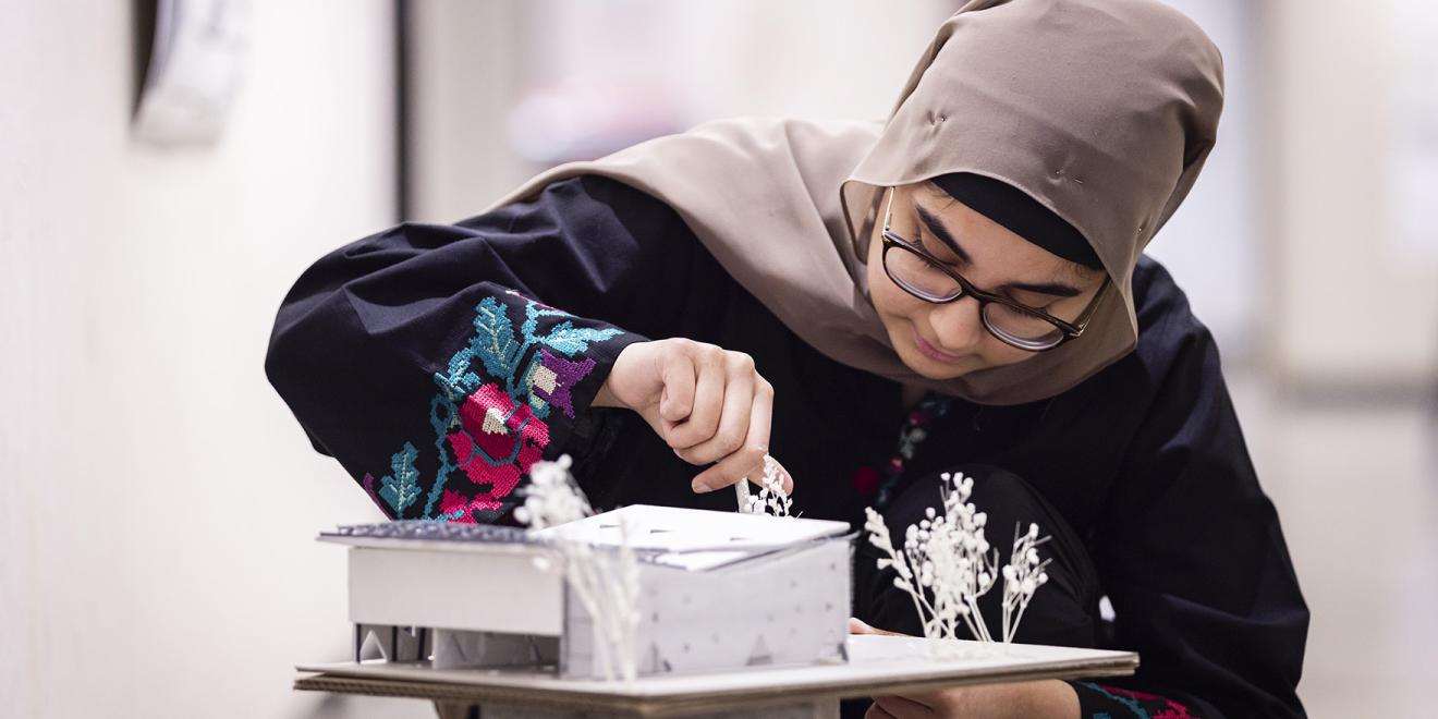 Student reviewing architecture model