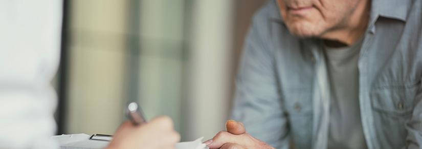 Close up of two people, with one person taking notes