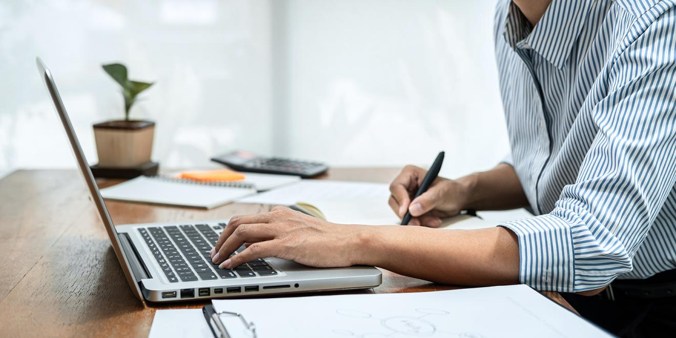 Business woman reading report on laptop