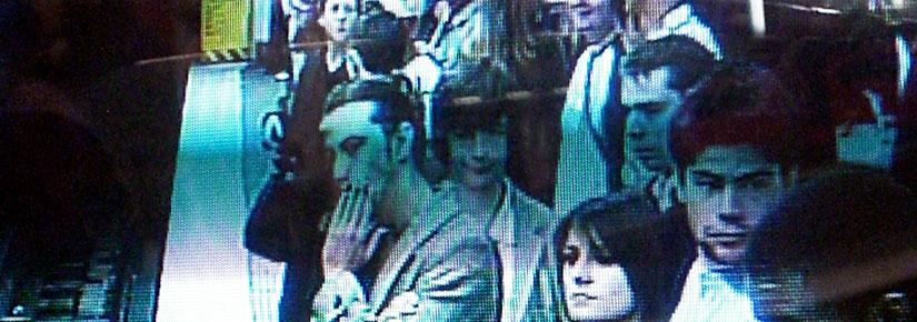 A group of people on a train station pictured on a security screen. Picture by marcokalmann on Flickr, CC BY-NC-ND 2.0