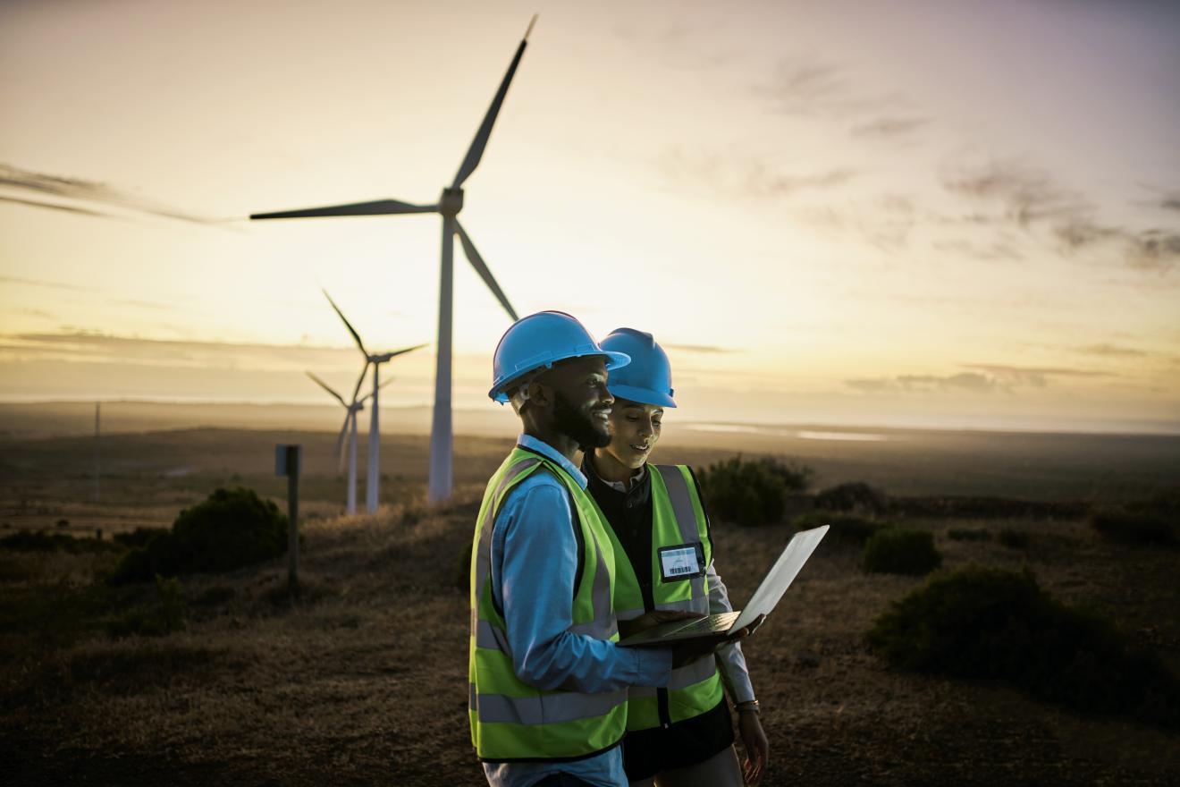 Two renewable energy workers infront of solar windmills.