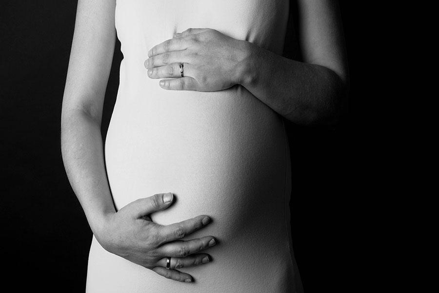 A pregnant woman holds her belly