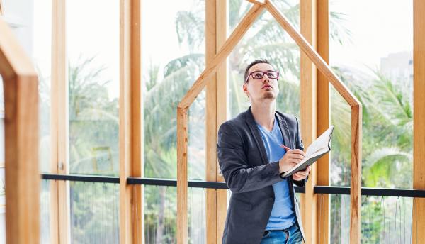 A man on examines construction plans on a building site