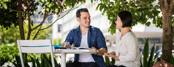 Two students studying under a tree