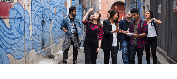 A group of students walking down a colourful laneway