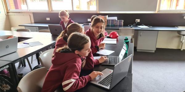 3 girls working together on laptops