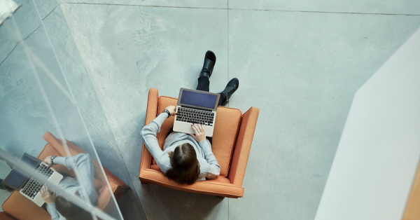 A student sitting in a chair working on a laptop