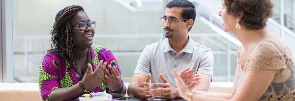 Three students in animated discussion