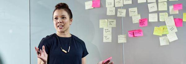 Student presenting with wall of post-its