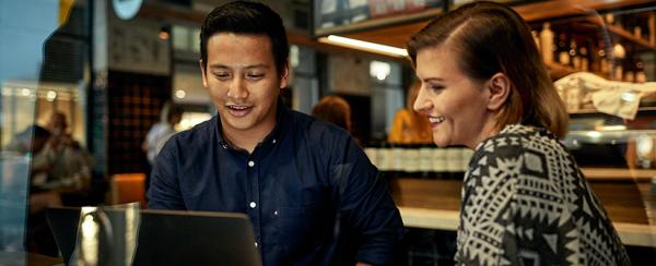 Two people sitting and looking at a computer screen together