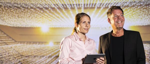 Two researchers look towards a projection of lights