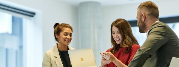 students looking at laptop and phone