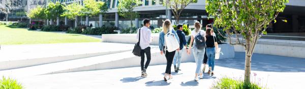 Several students walking towards a building