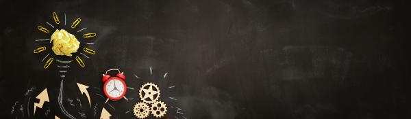 Blackboard with alarm clock, cog wheels, flower made from yellow paper and clips