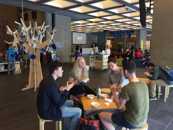 SDG students sitting at tables eating food