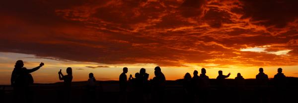 People viewing bushfires, silhouette against red sky