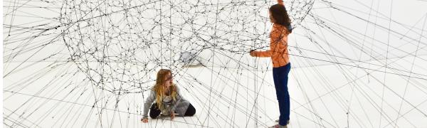 Two people in front of an illustration of a complex model