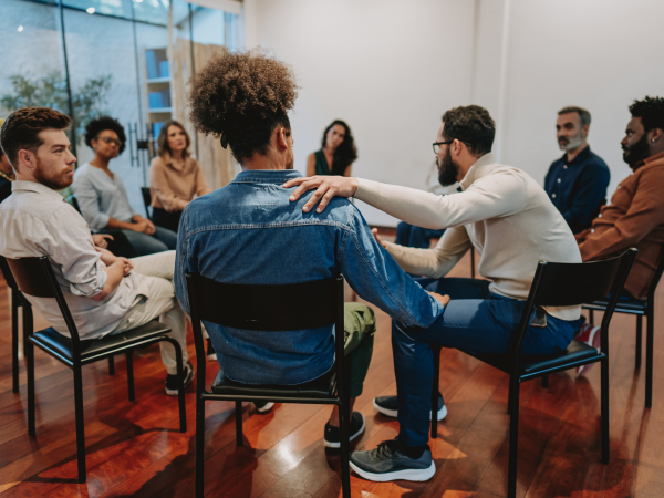 A group of people sitting in a circle facing each other and making conversation.