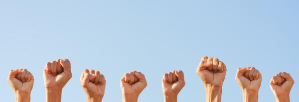 Multiple women's fists raised 