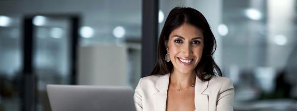 Female sitting at desk in evening with laptop