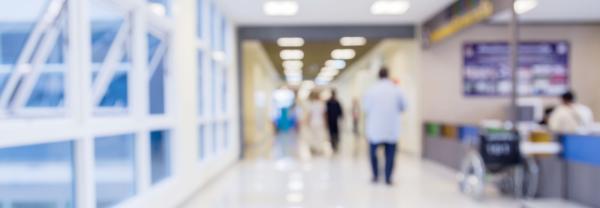 Blurry hospital corridor with people walking in the distance