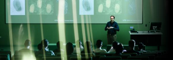 Students listening to forensic science lecture in green-coloured lecture hall
