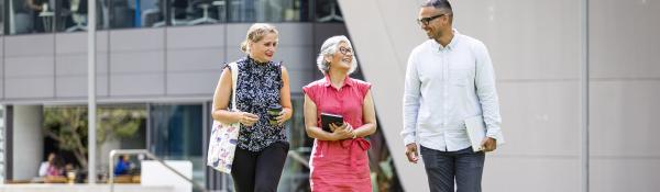 three academics walking on alumni green