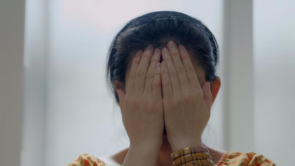 A woman with her hands over her face 